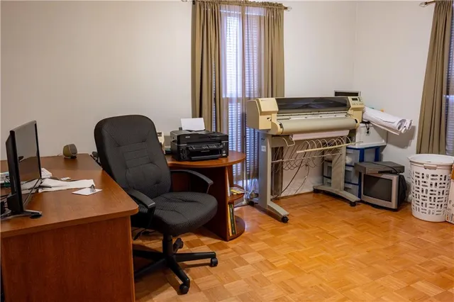 a view of a workspace with furniture and a window