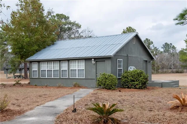 a front view of a house with a garden and plants