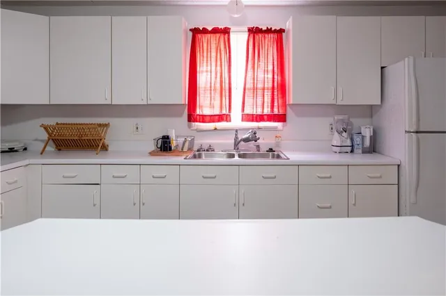 a kitchen with a sink window and cabinets