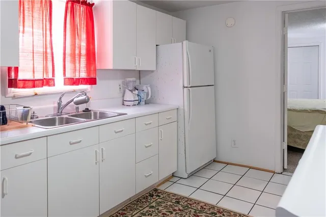 a kitchen with a sink a refrigerator and cabinets
