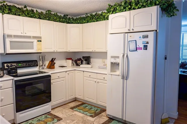 a white refrigerator freezer and a stove sitting inside of a kitchen