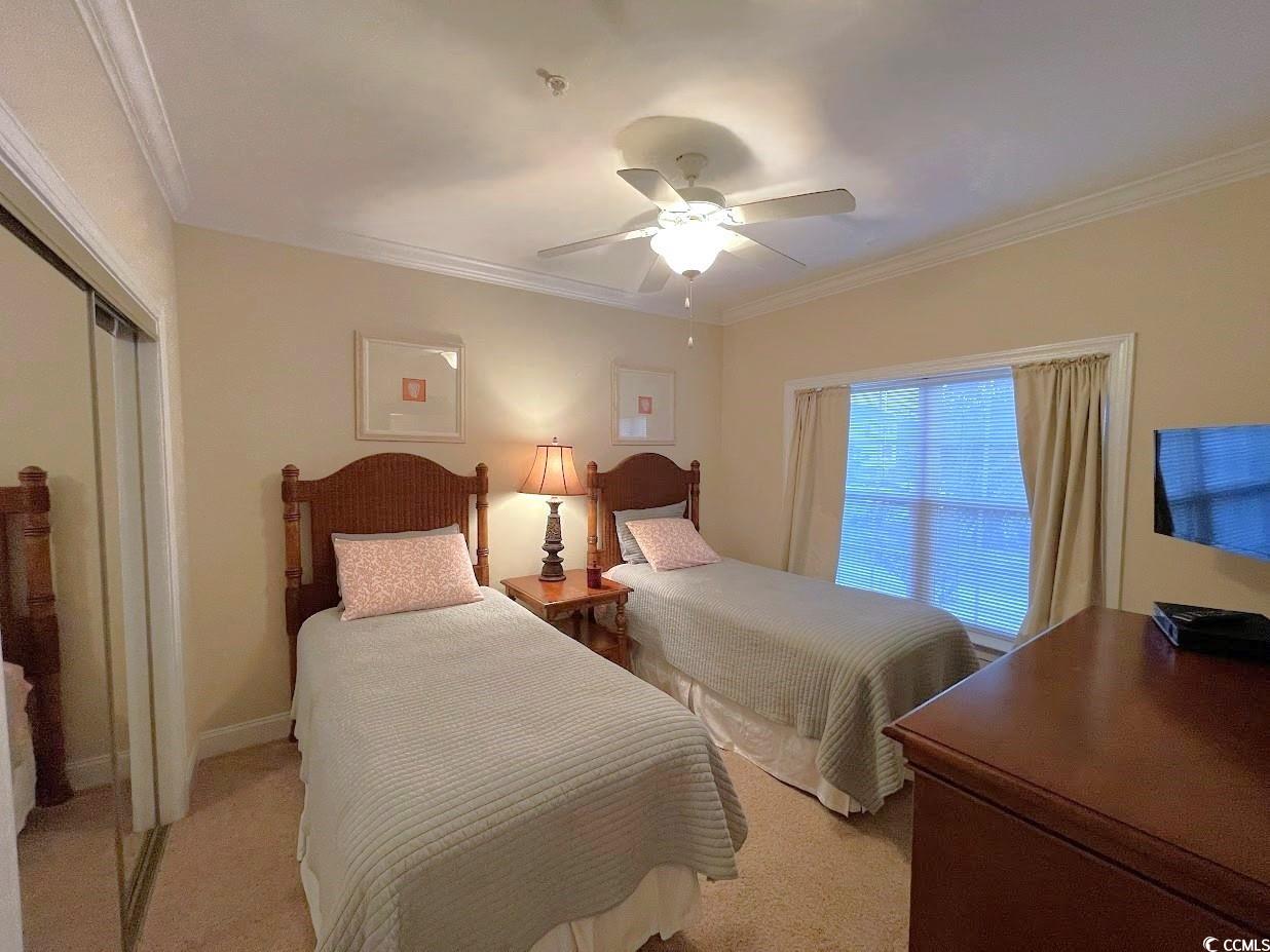 1008 Ray Costin Way, Unit 310 Murrells Inlet, SC 29576 - Photo 4 of 40 Carpeted bedroom featuring crown molding, ceiling fan, and a closet