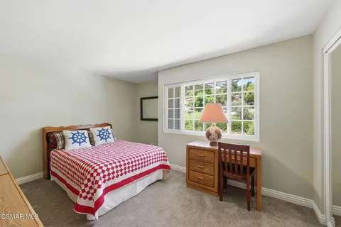 a bedroom with a bed chair and a window