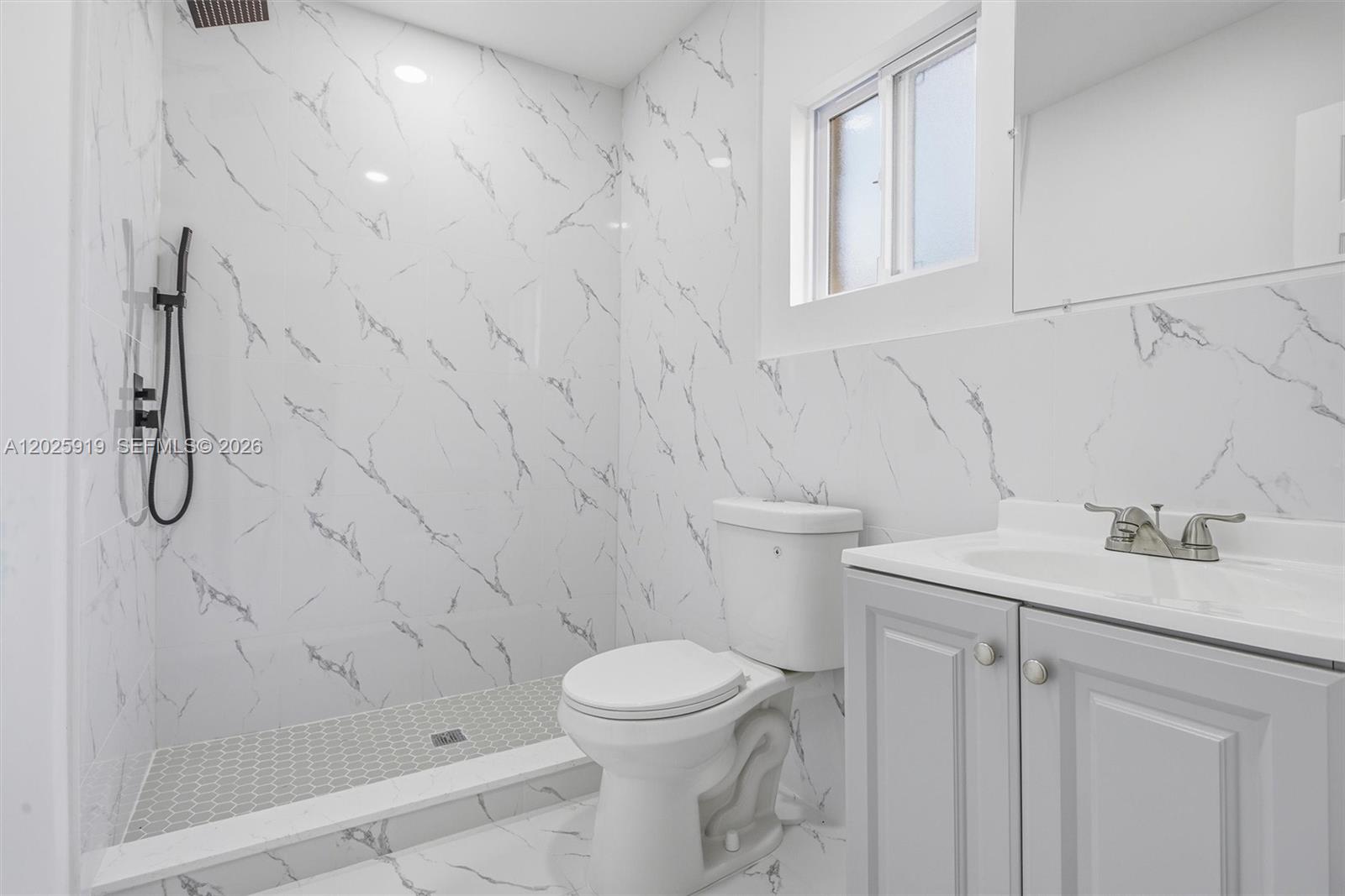 1743 Southwest 17th Street, Unit 1 Miami, FL 33145 - Photo 16 of 32 a bathroom with a granite countertop sink a toilet and a mirror