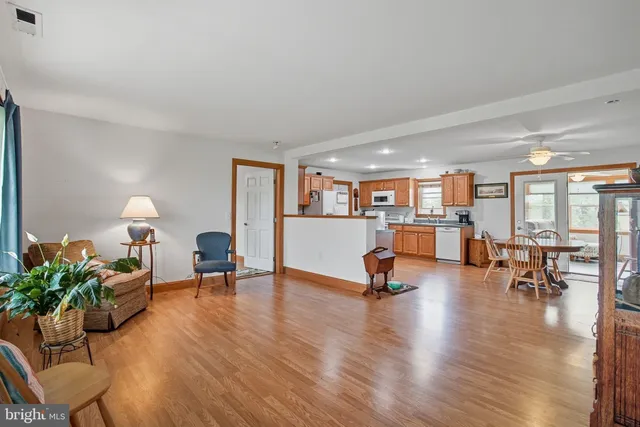 a kitchen with stainless steel appliances granite countertop a refrigerator a sink dishwasher a stove with wooden cabinets and floor