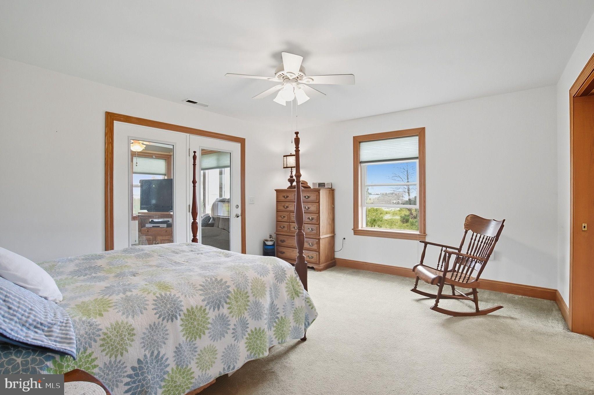 5304 Cassons Neck Road Cambridge, MD 21613 - Photo 17 of 46 a bedroom with a bed a chair and next to a window