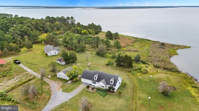a front view of a house with a garden and trees