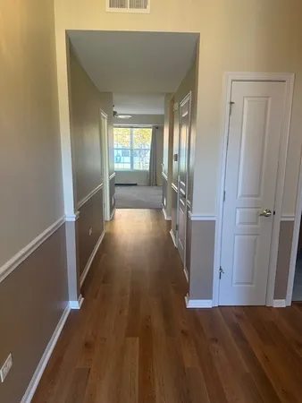 a view of a hallway with wooden floor and staircase