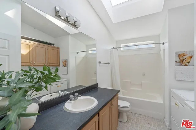 a bathroom with a granite countertop sink toilet a large mirror a shower and a bathtub