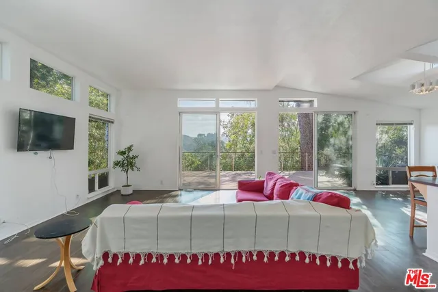 a bedroom with a bed and large windows