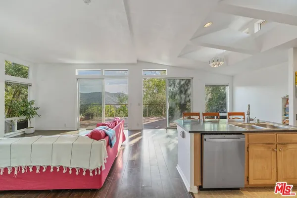 a kitchen with kitchen island granite countertop a sink and dishwasher with wooden floor