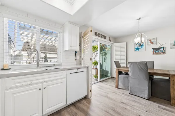 a kitchen with cabinets a sink dining table and chairs
