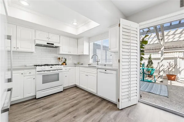 a kitchen with granite countertop white cabinets and white appliances