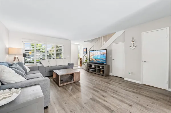 a living room with furniture a flat screen tv and a large window