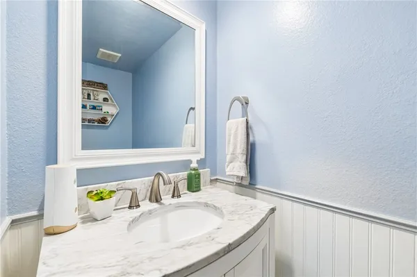 a bathroom with a granite countertop sink a bathtub and a window