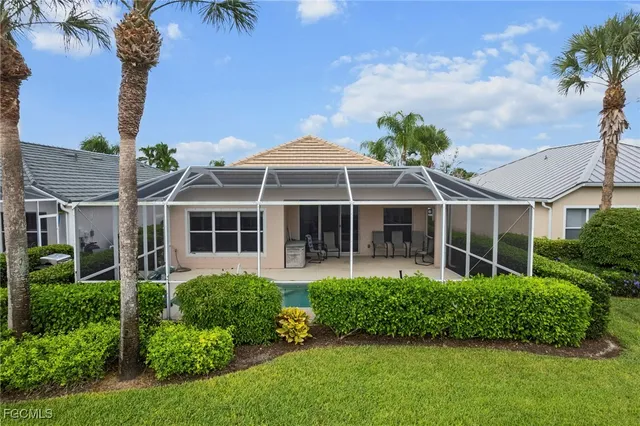 a front view of a house with a yard and potted plants