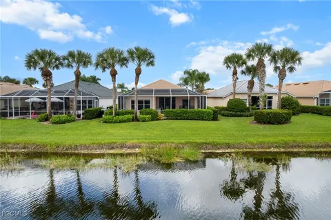 a front view of a house with a yard and potted plants