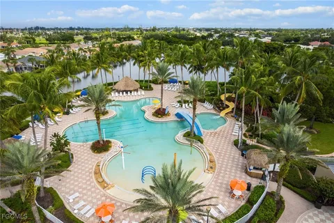 an aerial view of a house with swimming pool and lake view