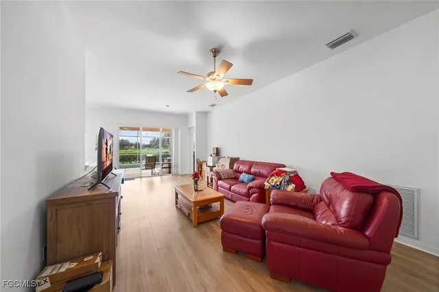 a living room with furniture a ceiling fan and a rug