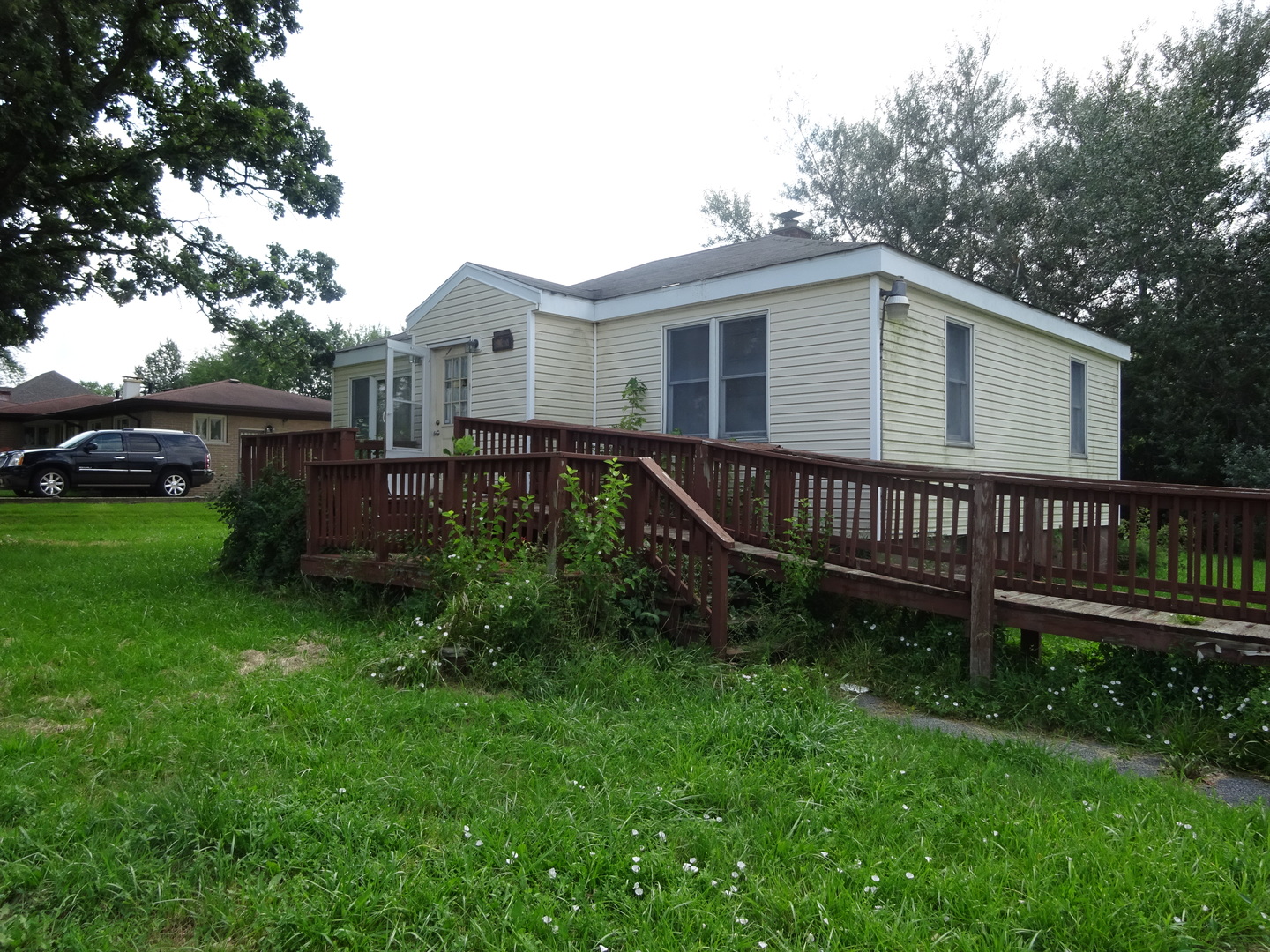 a view of a house with a yard and deck