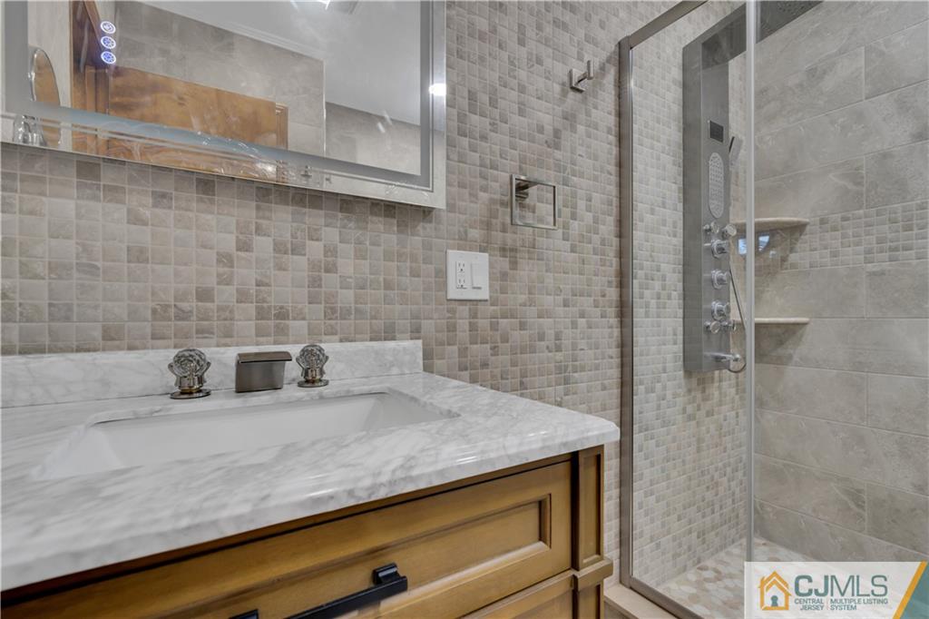 16 Channing Road East Brunswick, NJ 08816 - Photo 23 of 36 a bathroom with a sink a vanity and shower