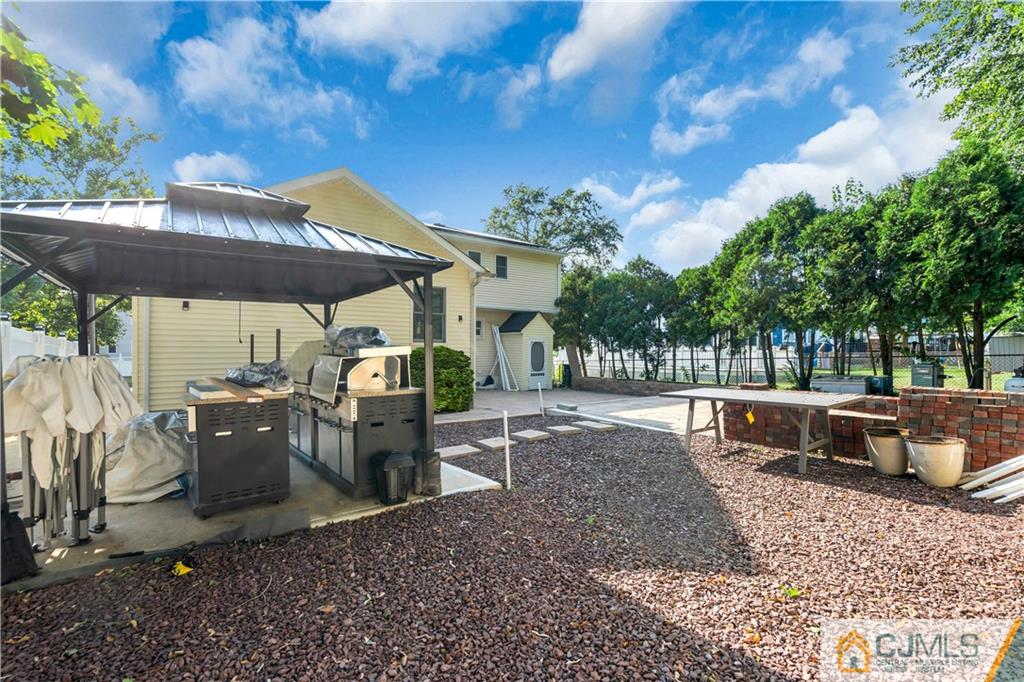 16 Channing Road East Brunswick, NJ 08816 - Photo 36 of 36 a patio with a table and chairs under an umbrella