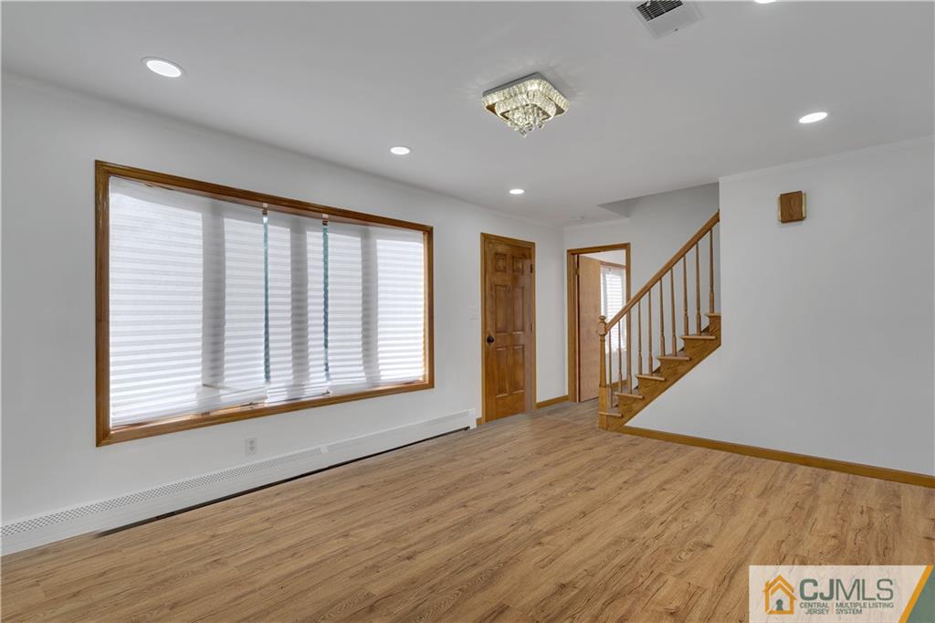 16 Channing Road East Brunswick, NJ 08816 - Photo 6 of 36 a view of an empty room with a window and wooden floor