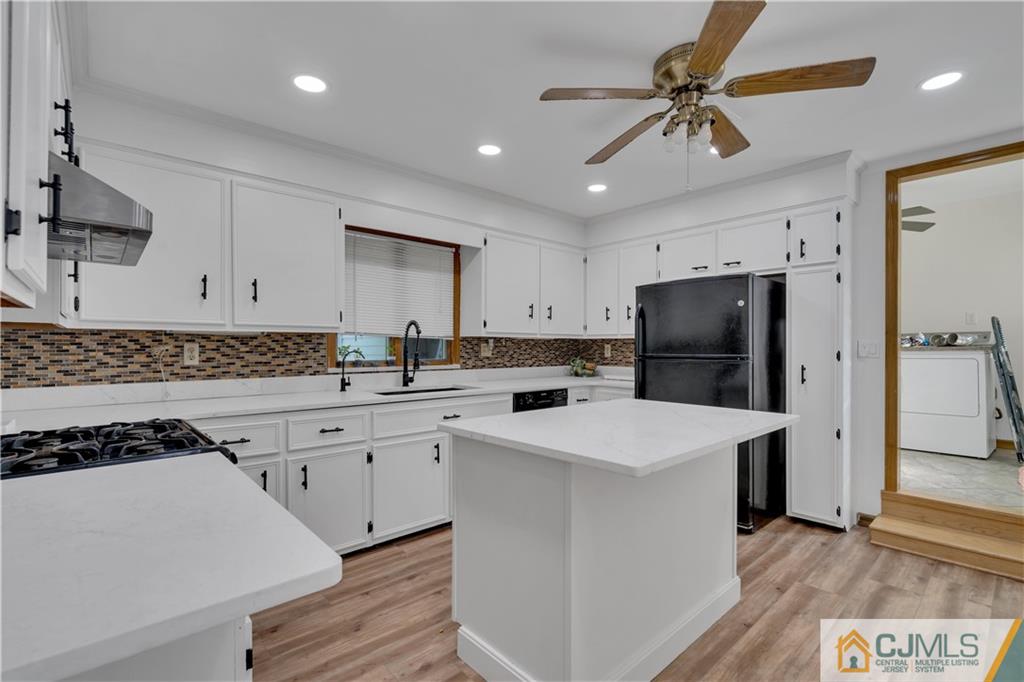 16 Channing Road East Brunswick, NJ 08816 - Photo 9 of 36 a kitchen with a refrigerator a sink and cabinets