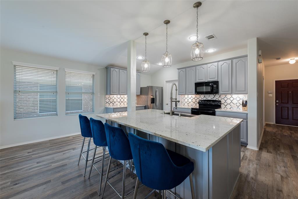a kitchen with stainless steel appliances a kitchen island a stove a table and chairs in it