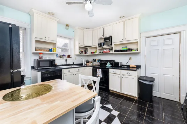 a kitchen with granite countertop a sink stainless steel appliances and white cabinets