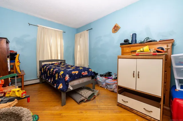 a bedroom with a bed and wooden floor