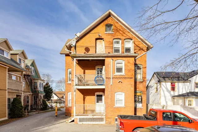 a front view of a residential apartment building with a yard
