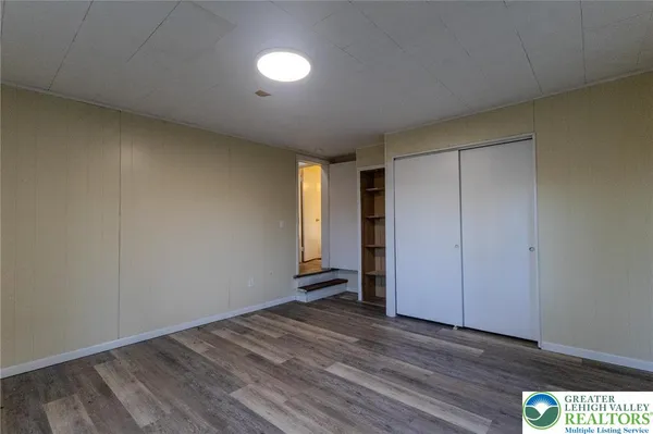 a view of empty room with wooden floor