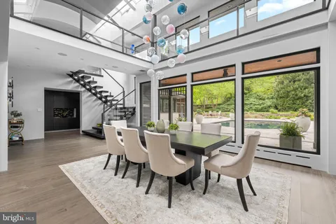 a dining room with furniture a chandelier and wooden floor