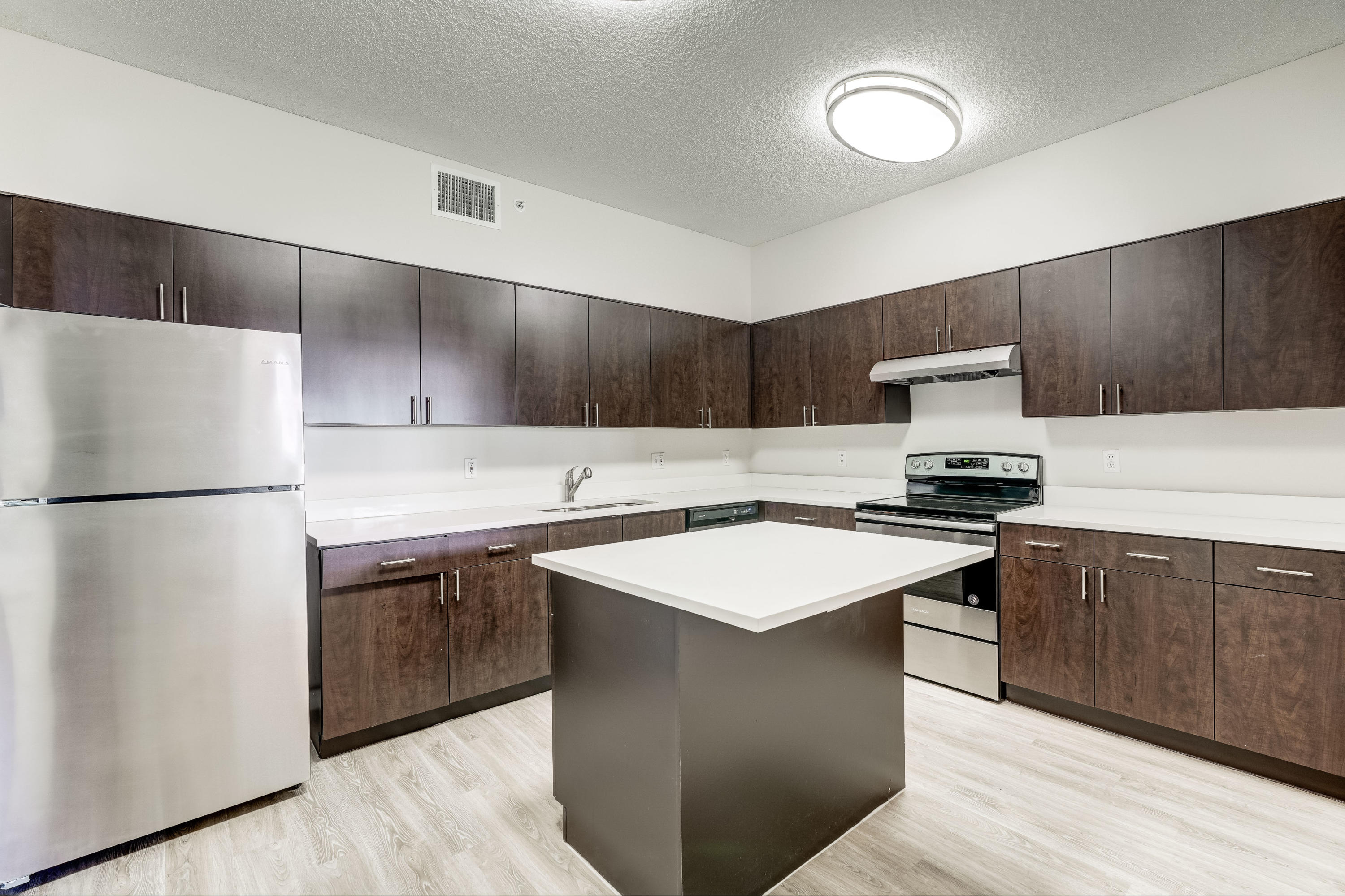 4685 Haverhill Road, Unit A8 West Palm Beach, FL 33417 - Photo 12 of 33 a kitchen with stainless steel appliances a refrigerator sink and white cabinets