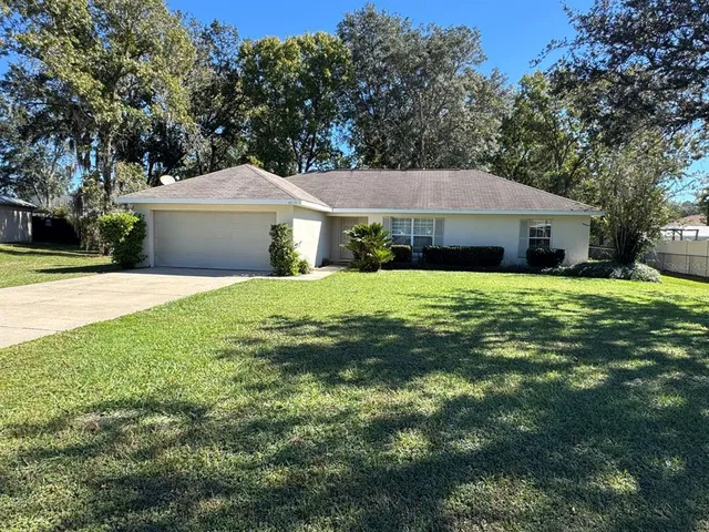 a front view of a house with yard and green space