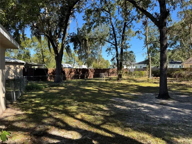 a view of a yard with large trees