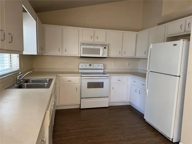 a kitchen with cabinets appliances a sink and a counter space