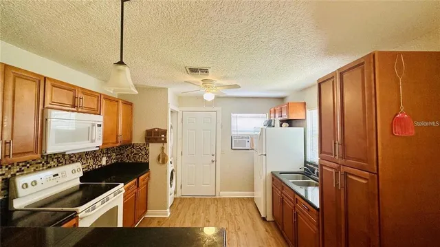 a kitchen with stainless steel appliances granite countertop a refrigerator and a stove top oven