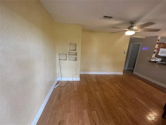 a view of empty room with wooden floor