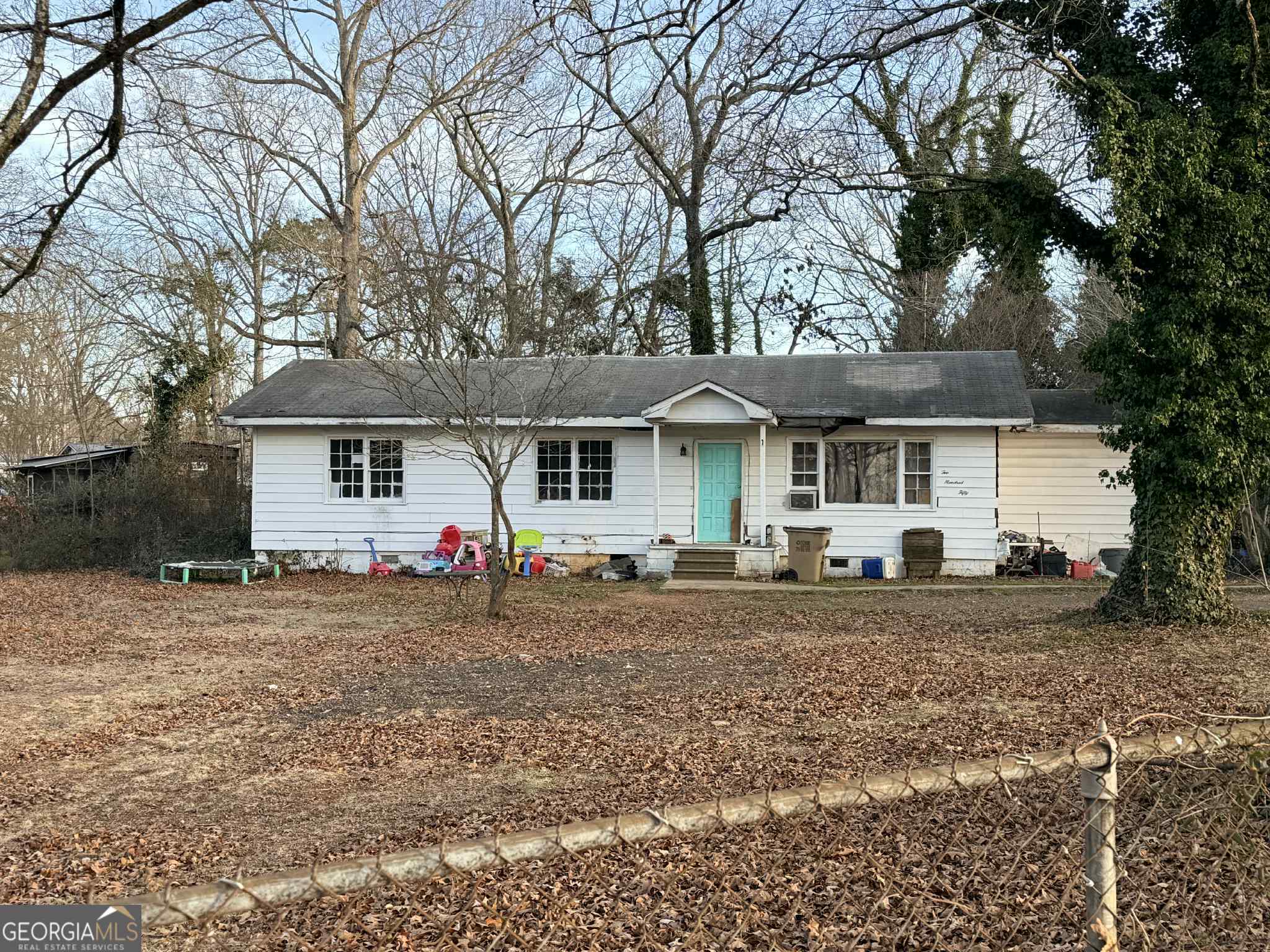 a view of a house with a yard and a large tree