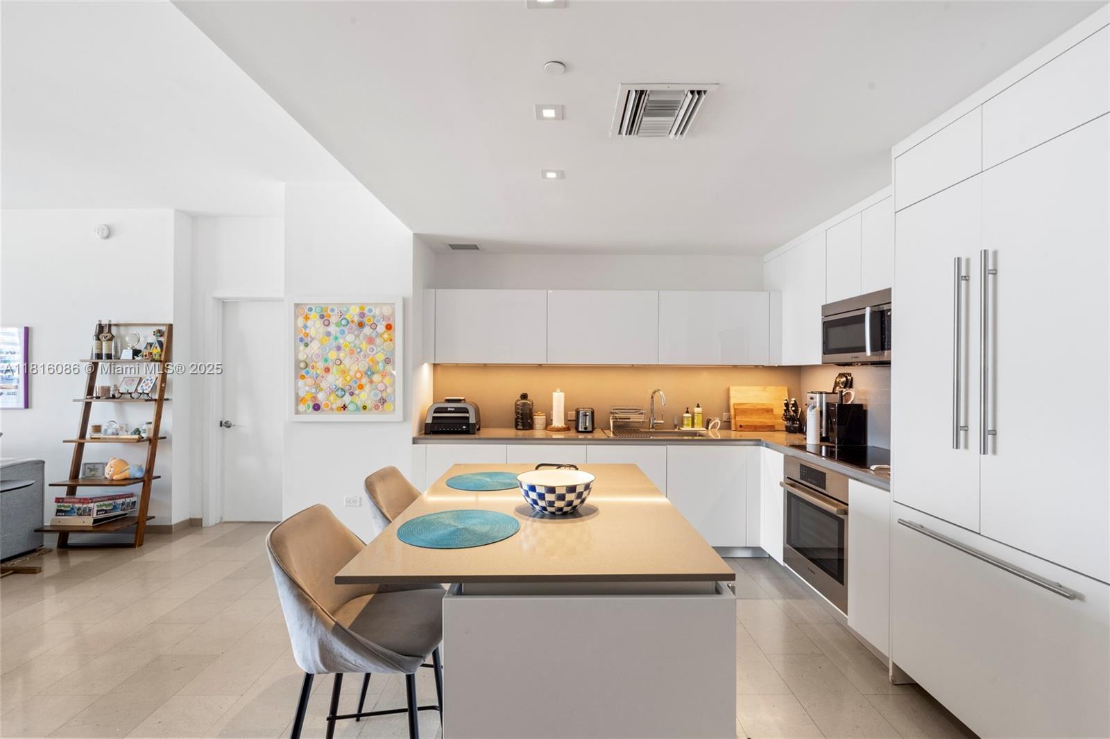 a kitchen with a sink a stove and chairs
