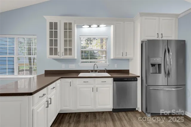 a kitchen with granite countertop white cabinets and stainless steel appliances