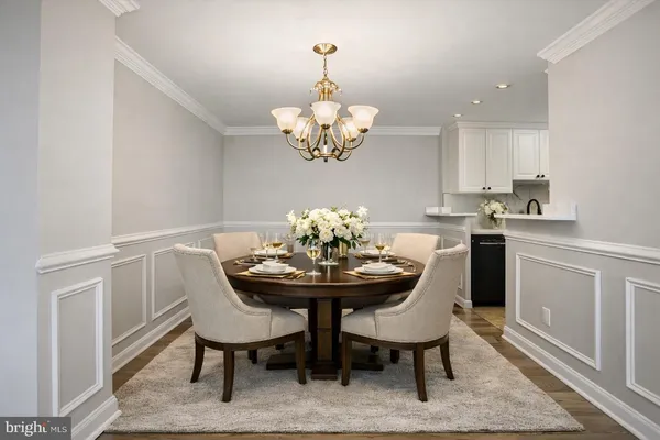 a dining room filled chandelier and wooden floor
