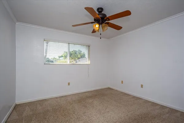 an empty room with a window and a fan