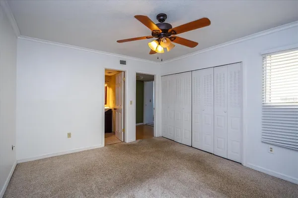 a view of a bedroom with a ceiling fan and a window