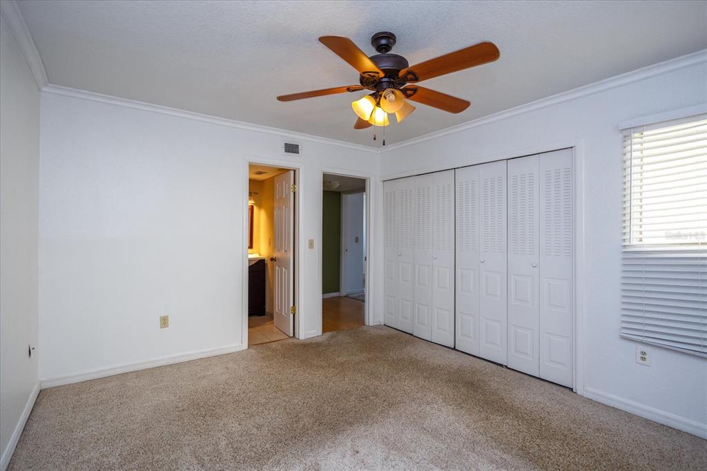 908 Lake Destiny Road, Unit E Altamonte Springs, FL 32714 - Photo 17 of 20 a view of a bedroom with a ceiling fan and a window