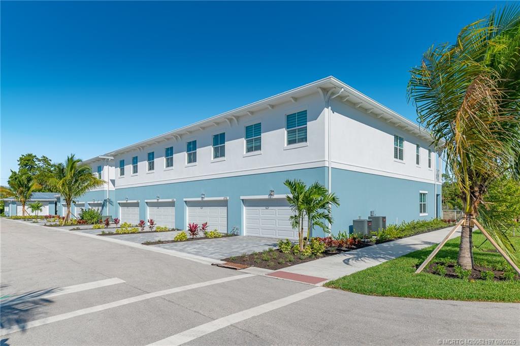 4674 Southeast Manatee Terrace Stuart, FL 34997 - Photo 22 of 55 a front view of a house with a yard and garage