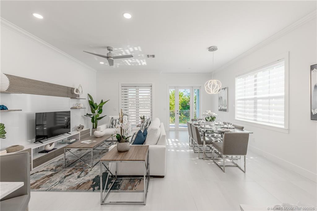 4674 Southeast Manatee Terrace Stuart, FL 34997 - Photo 29 of 55 a living room with furniture a fireplace and a chandelier