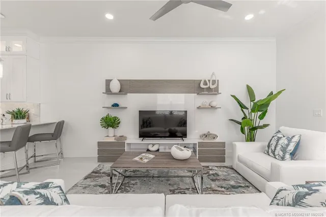 a view of a dining room with furniture a chandelier and large windows